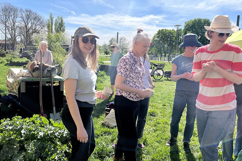Gärtnern in der Stadt, Personen bei gutem Wetter im Garten.