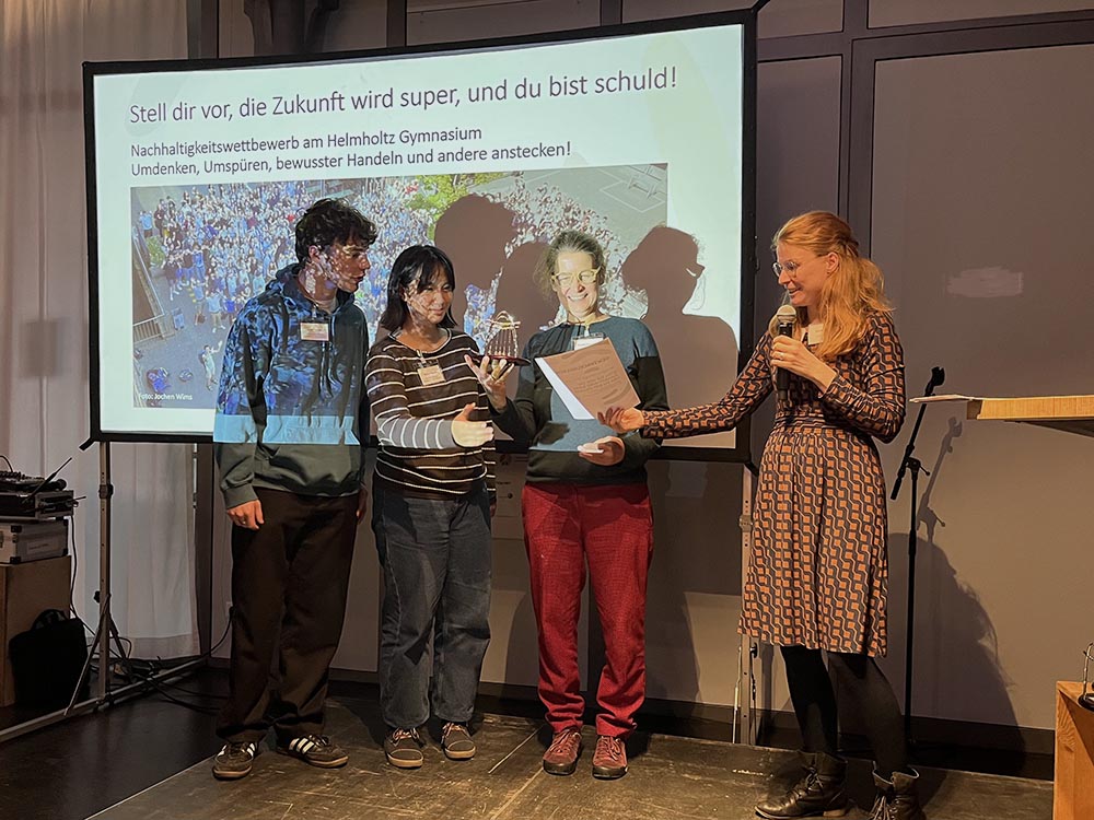 Urkundenverleihung auf einer Bühne.