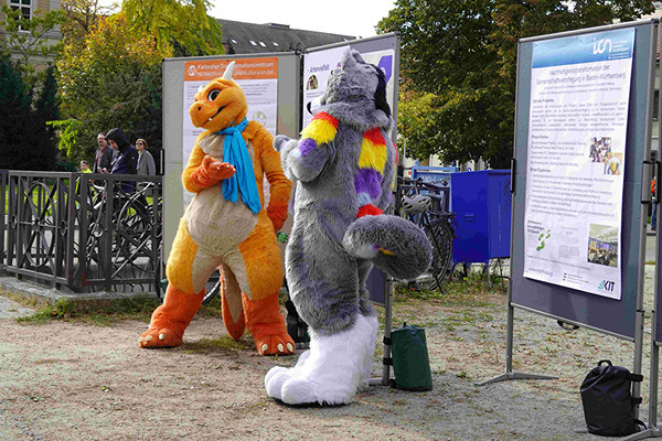 Flauschige Besucher betrachten den KAT-Infostadt am Friedrichsplatz.