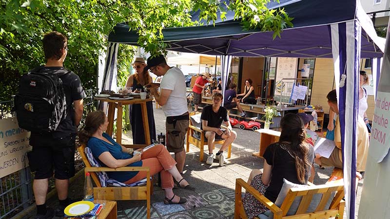 Sitzgruppe mit Personen im Freien. 