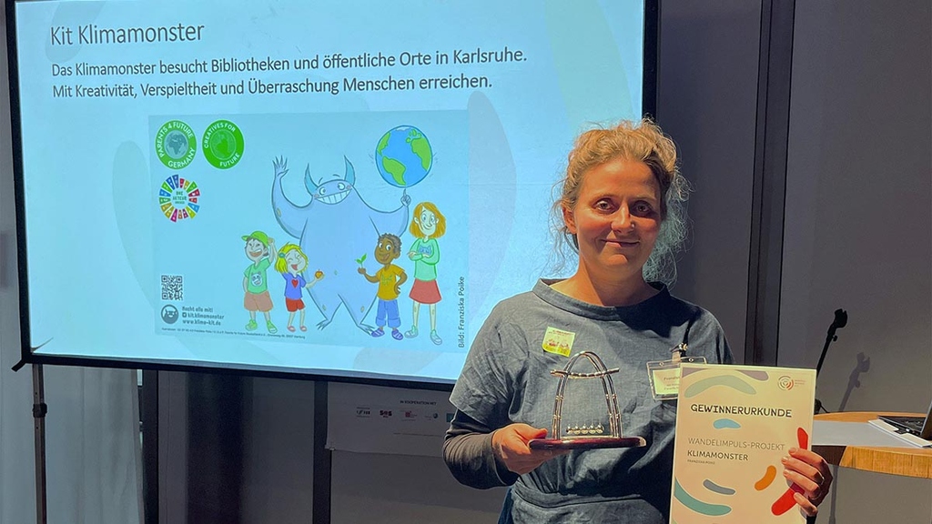 Franziska Poike nimmt Auszeichnung für Projekt Kit Klimamonster entgegen.
