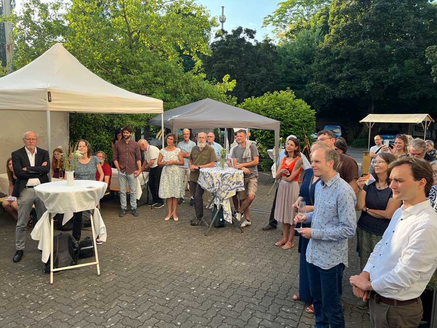 Jubiläumsfeier vor dem Zukunftsraum mit fröhlichen Menschen.