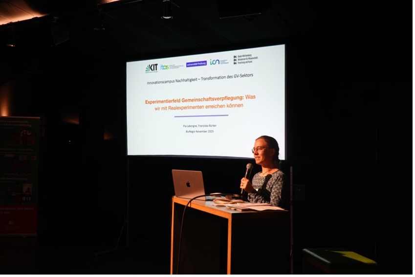 Referentin steht hinter einem Pult.