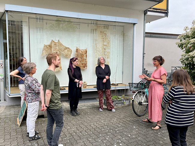 Gruppe von Menschen steht vor dem Zukunftsraum mit Kunstobjekten.