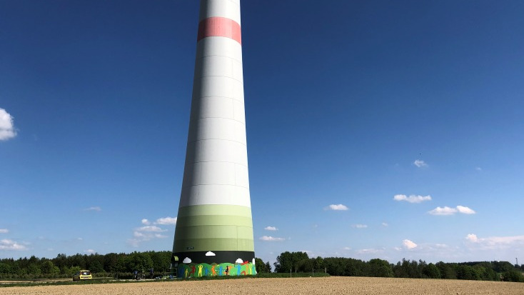 Der bunte Windradsockel mit aufgemalter Kunst von weiter weg.