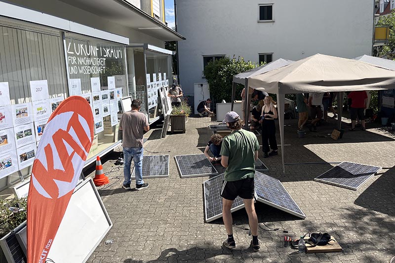 Personen bei einem Solarmodul-Workshop vor dem Zukunftsraum. 